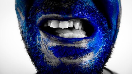 Face covered in blue paint with raised beard hair and cross mouth with visible teeth, blue artistic concept, crazy smile 