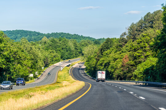 Front Royal, USA - May 27, 2021: Green summer forest trees in rural countryside in Virginia Blue Ridge Mountains with cars and FedEx truck in traffic morning on hill on i66