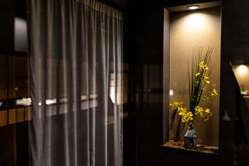 Traditional Japanese house or ryokan home hotel with yellow flower ikebana in vase decoration decor...