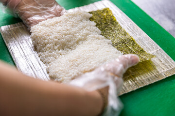 Woman's hands making japanese rolls