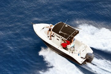 Angled overhead view of a sport fishing boat speeding off of the coast of Cozumel,`Mexico.