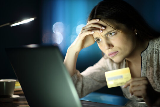 Worried woman in the night buying online at home