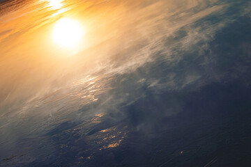 Ice on the water surface. Background image with sunset and ice. Reflection on ice.