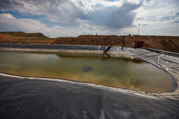 Almaty region, Kazakhstan: Extraction of gold ore. Mining and processing plant. Pond for chemical refining by sodium cyanide. - obrazy, fototapety, plakaty