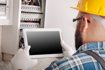An engineer or electrician worker working check the electrical system with tablet