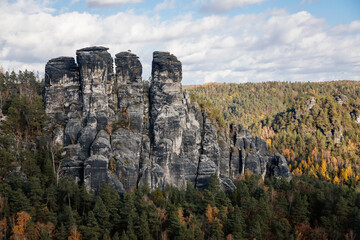 Fototapeta na wymiar Saxon Switzerland National Park, Germany, 6 November 2021: Basteiaussicht or Bastei Rock Formations in Elbe River Valley, Sandstone Mountains Path, autumn forest landscape at sunny day, rocky valley