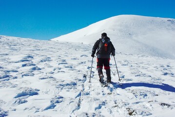 Fototapeta na wymiar climber climbing snowy mountain, with professional equipment