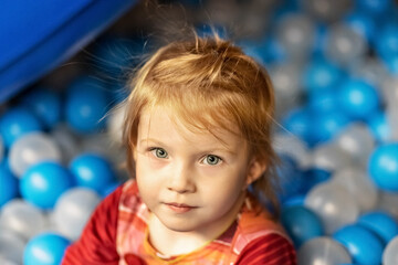 Fototapeta na wymiar Portrait of a little toddler girl with red hair in a ballroom
