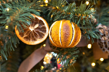 Christmas background of a Christmas tree decorated with cones, tangerines and oranges. Winter holidays. New Year.