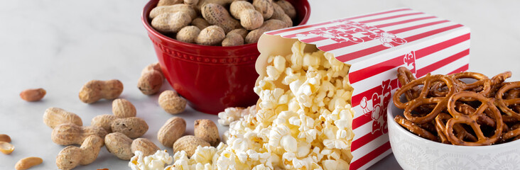 Narrow view of popular salty snacks with the box of popcorn tipped over.