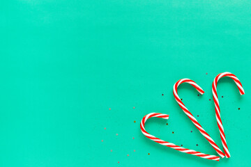 Christmas white and red candy canes on green background with copy space for text. Minimalistic...