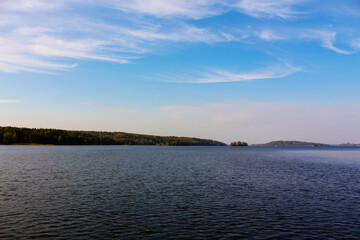 A beautiful landscape with a lake and blue sky and amazingly shaped clouds