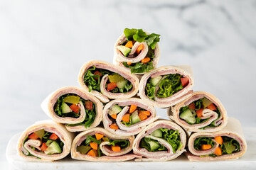 Freshly made deli wraps piled up in the shape of a pyramid.