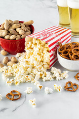 A vertical view of containers of snacks with glasses of beer in behind.