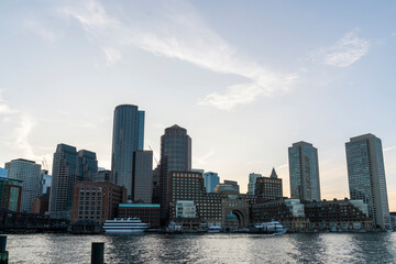 Fototapeta na wymiar Panoramic picturesque city view of Boston Harbour and Seaport Blvd at afternoon time, Massachusetts. An intellectual, technological and political center. Building exteriors of financial downtown.