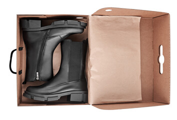Black leather female boots on paper box isolated on white background, copy space. Delivery concept