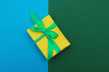 Yellow gift box on blue and green background.