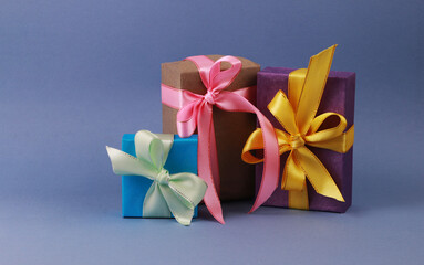 Three multicolored gift boxes on blue background.
