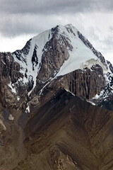 Beautiful high mountain with rocks, snowfields, glaciers and rocky scree.