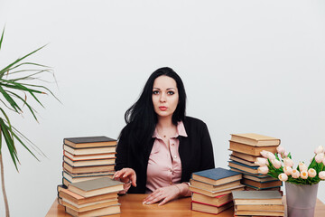 beautiful brunette woman at her desk with books for learning