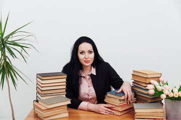 beautiful brunette woman at her desk with books for learning