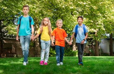 Group of schoolchildren walking together on the park
