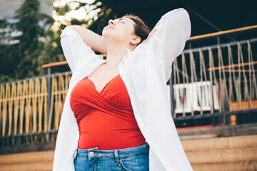 Plus size fashion model in red bikini at resort.