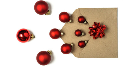 Open envelope from craft paper with red paper from which Christmas red balls have spilled out, isolated on white background.