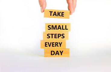 Take small steps every day symbol. Wooden blocks with words Take small steps every day. Beautiful white background, copy space. Businessman hand. Business, step every day concept.