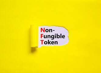 NFT non-fungible token symbol. Concept words NFT non-fungible token on white paper. Beautiful yellow background, copy space. Business and NFT non-fungible token concept.