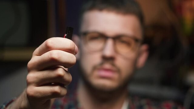 Hacker holding usb flash drive close-up. Young man developing program, IT-specialist. Professional programmer infecting system with cyber virus, breaking password.