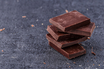 Chocolate cupcake with icing and chocolate bar in Dark lighting,Homemade delicious chocolate muffin on wooden background close-up