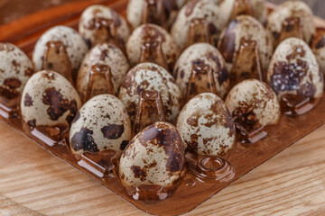 Fototapeta premium Group of quail eggs are put on clear tray on wooden table.