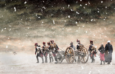 Napoleon soldiers marching in falling snow and pulling a cannon with them. No recognizable people in the image