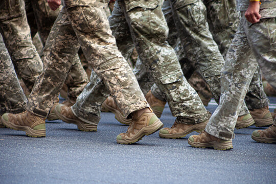 Selective focus. Motion blur. Modern military footwear on soldiers. A soldier in uniform is marching in the parade. People in the crowd. Boots on the foot.