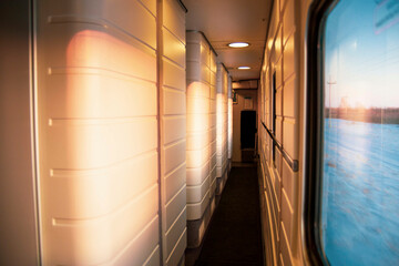 view from the window of a high-speed train in the aisle of a compartment, at sunset, the foreground...