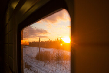view from the window of a high-speed train in the aisle of a compartment, at sunset, the foreground and background are blurred with bokeh effect