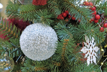 Snow-covered Christmas ball on the Christmas tree. Snowball.