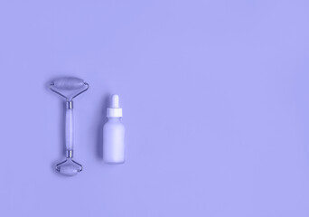 Beautiful composition of mockup serum bottle and quarts stone face roller. Toned in trendy color of...