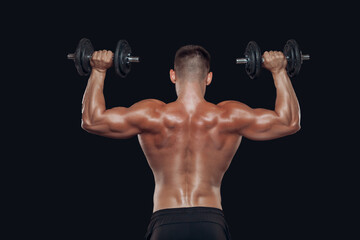 Fototapeta na wymiar Close up back view of muscular body and strong hands lifting heavy dumbbells isolated over black background