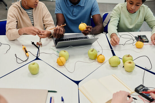 Cropped shot of African-American teacher working on science experiments with diverse group of children