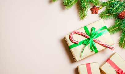 Handmade gifts decorated with colorful ribbons on a background decorated with fir branches. Blurry, defocused, selective focus. Copy space