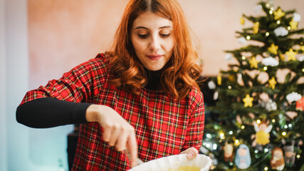 Giovane ragazza cucina un dolce a Natale