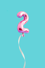 Fototapeta Number two shape made with pink balloon and ribbon against bright blue background. Anniversary concept. Creative idea of Love or valentine days. obraz