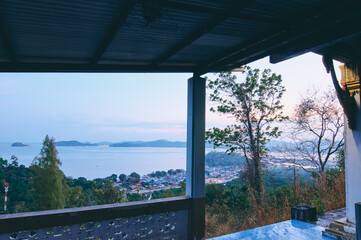 Fototapeta na wymiar Beautiful view from a hilltop capturing coastal town and it's calming bay. Phuket, Thailand.