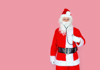 A male doctor in a Santa Claus costume with a stethoscope listens to his heart. Healthcare concept