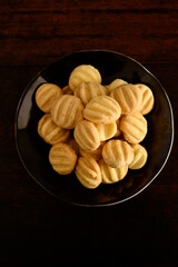 cookies in black plate on wooden table, baker's day, top view