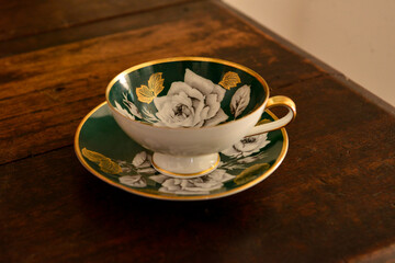 green and gold porcelain cup and saucer, luxury porcelain cup, porcelain coffee cup, cup of coffee on the table , vintage decor, world coffee day, coffee shop