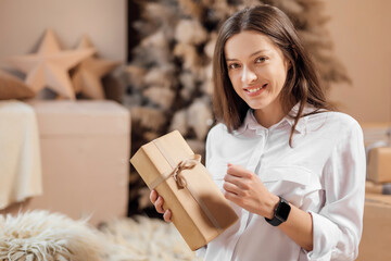 Young woman is wrapping christmas presents for holidays