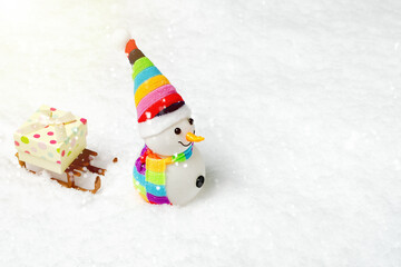 Christmas snowman with gift box on the sled. LGBT colors
